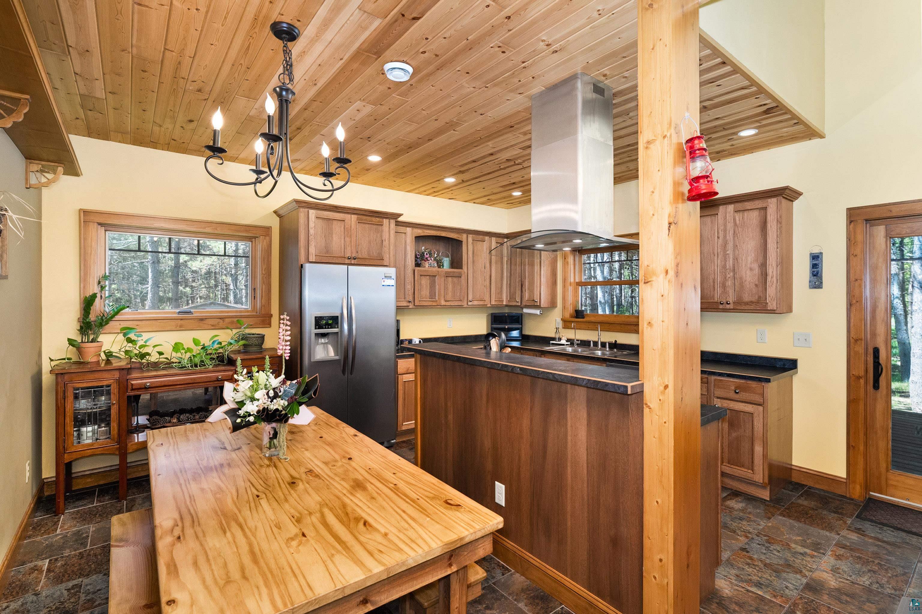 75 East Stark Road Esko, MN 55733 - Photo 19 of 87 Open-concept kitchen and dining area featuring wood-finish cabinetry, stainless steel appliances, and a central island with countertop seating