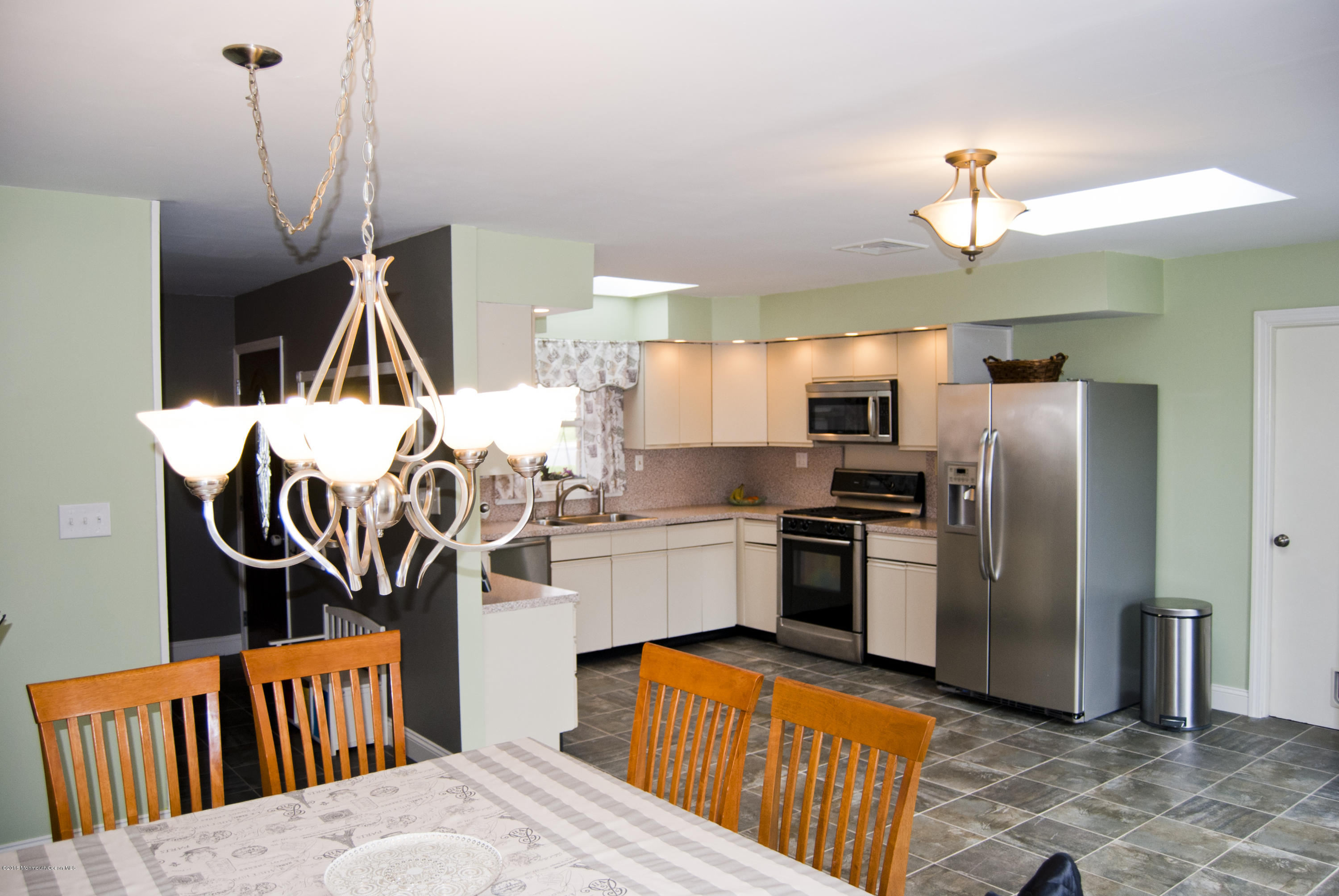 439 Line Road Aberdeen, NJ 07747 - Photo 6 of 22 a kitchen with stainless steel appliances granite countertop a refrigerator a sink dishwasher a stove and a dining table with wooden floor