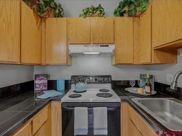 a kitchen with a sink a stove and cabinets