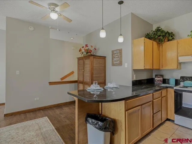 a kitchen with stainless steel appliances granite countertop a sink a stove and a wooden floors
