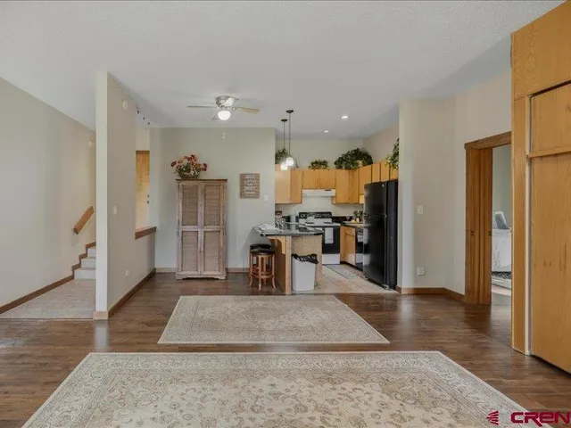 a view of a kitchen with refrigerator and wooden floor