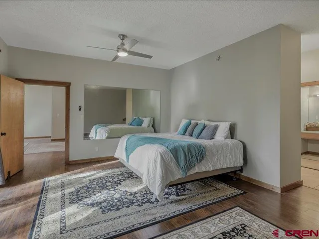 a spacious bedroom with a bed and wooden floor