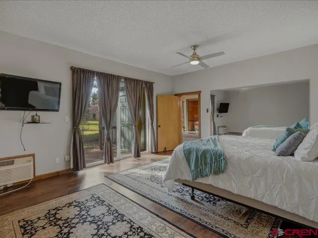 a living room with a bed furniture and a flat screen tv