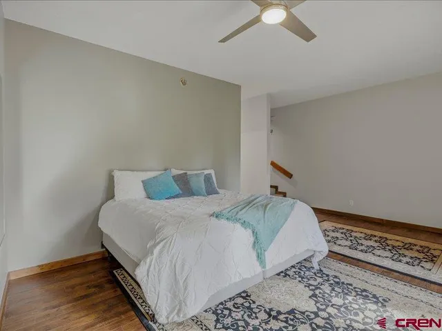a bedroom with a bed and a ceiling fan