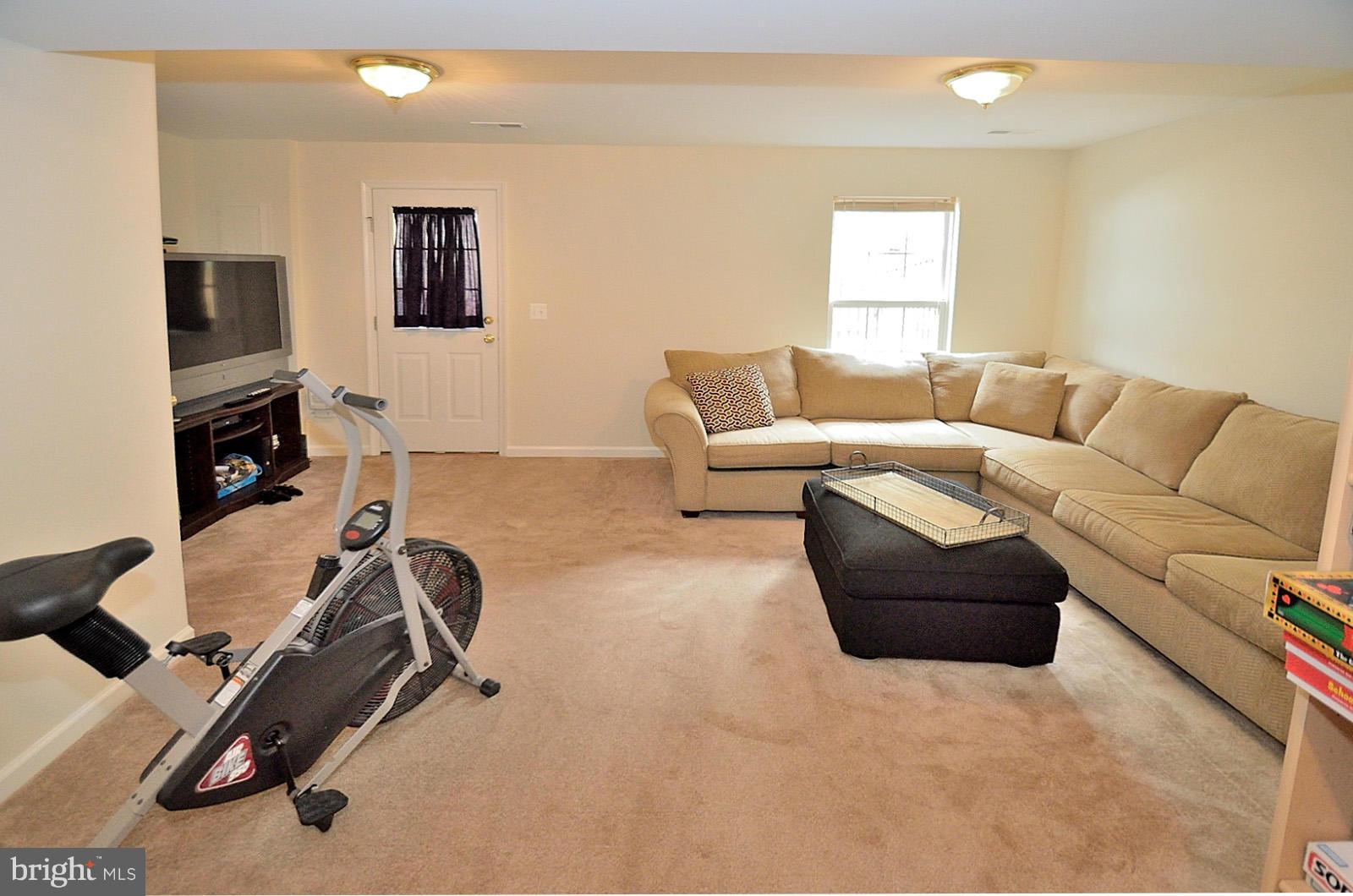 19933 Ridgecrest Square Ashburn, VA 20147 - Photo 11 of 19 a living room with furniture gym equipment and a flat screen tv