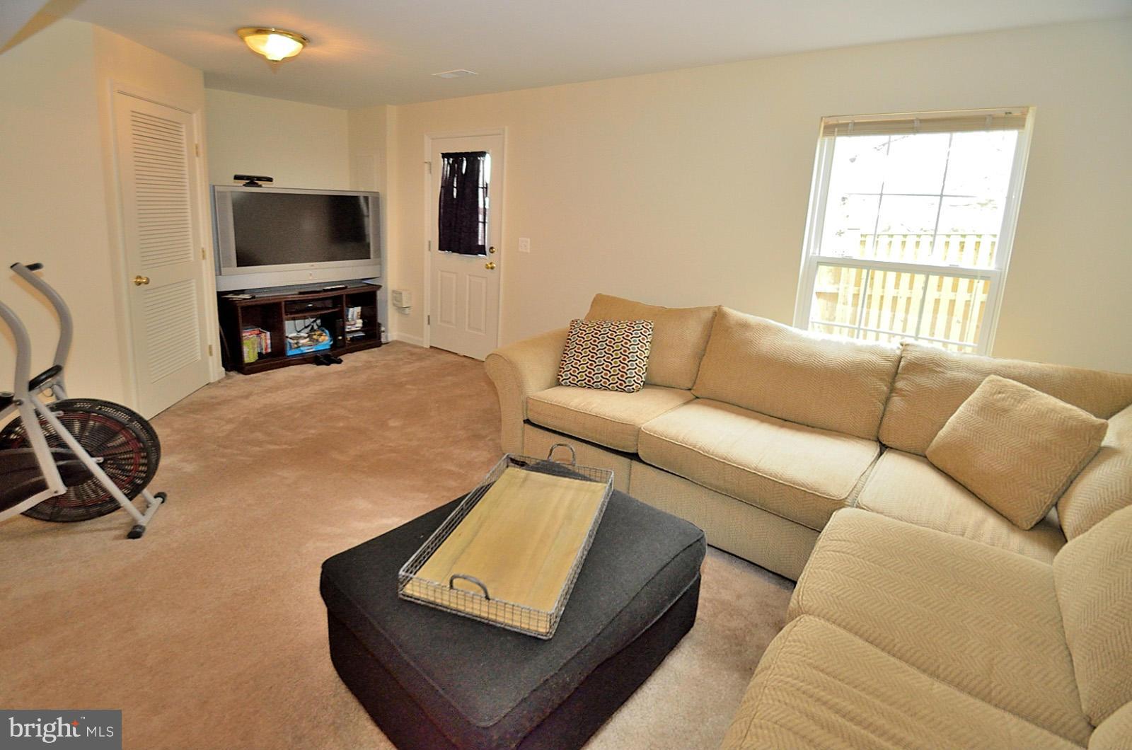 19933 Ridgecrest Square Ashburn, VA 20147 - Photo 12 of 19 a living room with furniture and a flat screen tv