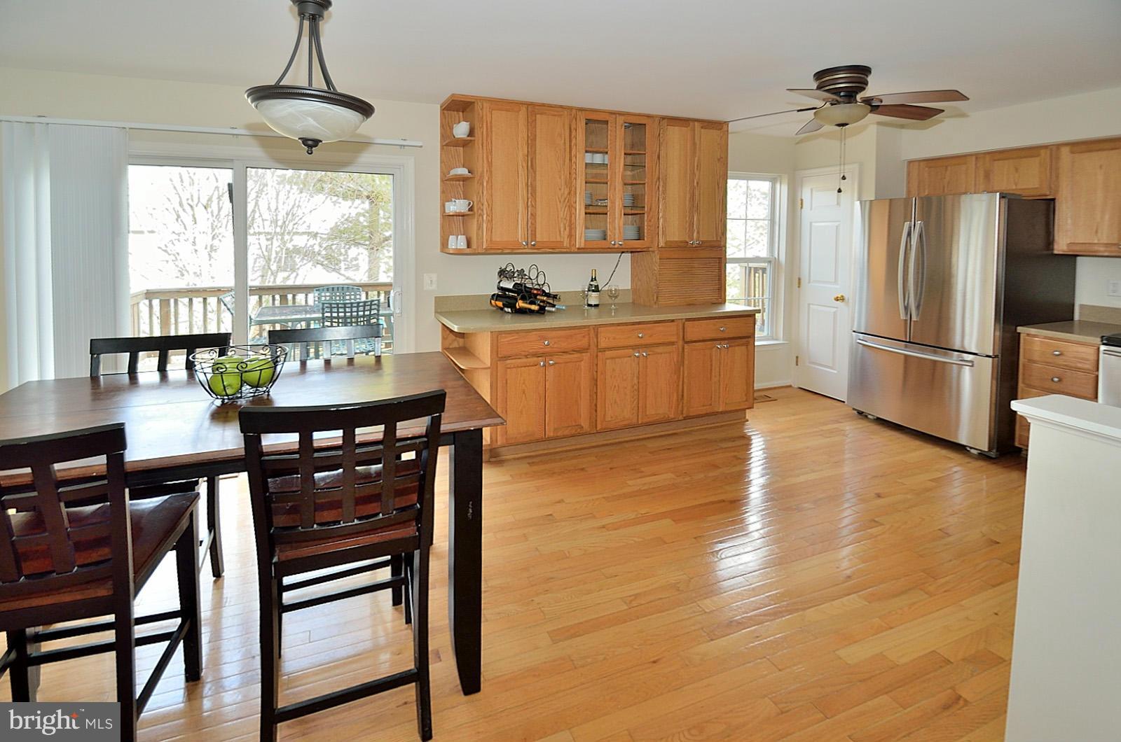 19933 Ridgecrest Square Ashburn, VA 20147 - Photo 3 of 19 a kitchen with stainless steel appliances wooden floor dining table and chairs