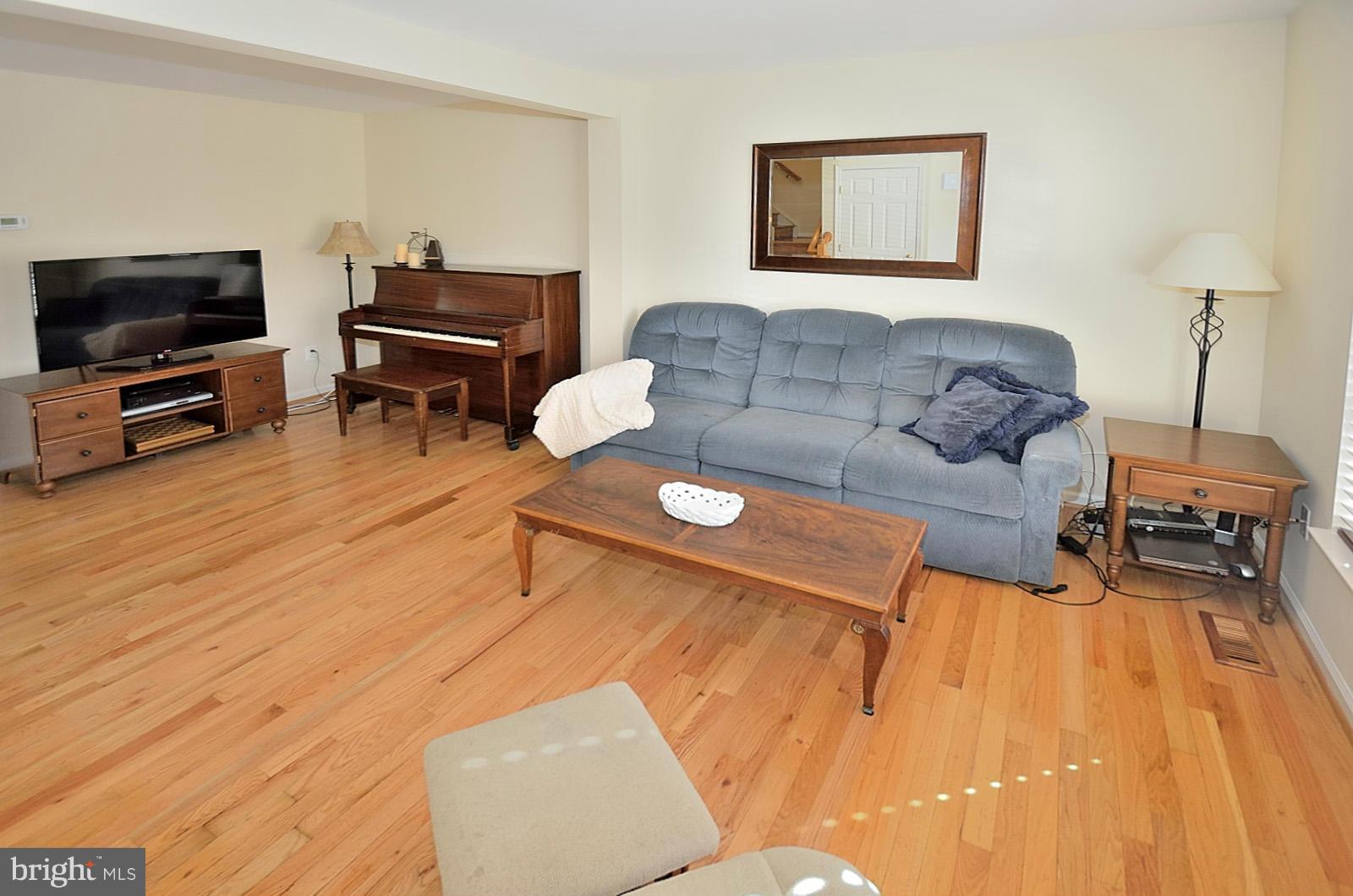 19933 Ridgecrest Square Ashburn, VA 20147 - Photo 9 of 19 a living room with furniture and a flat screen tv