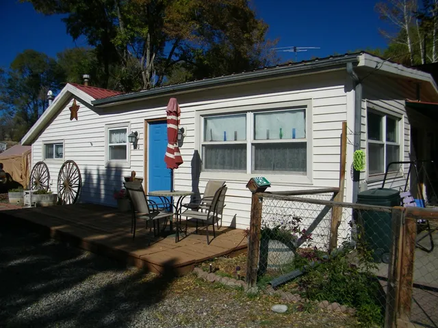 a view of house with backyard and outdoor seating
