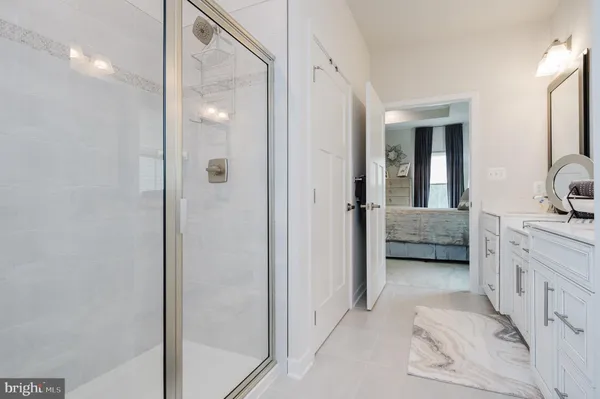 a en suite bathroom with a shower sink and mirror