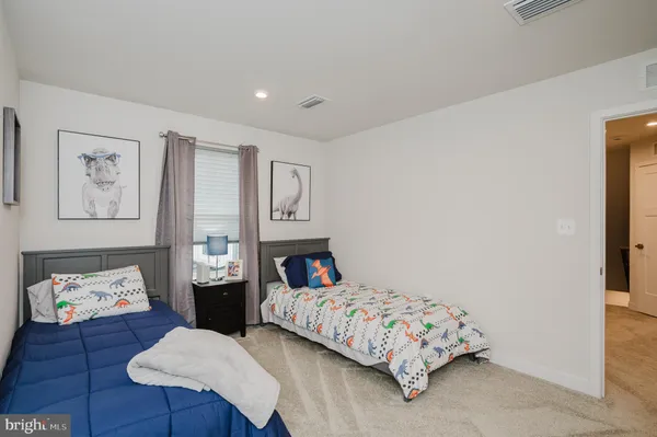 a bedroom with a bed couch and wooden floor