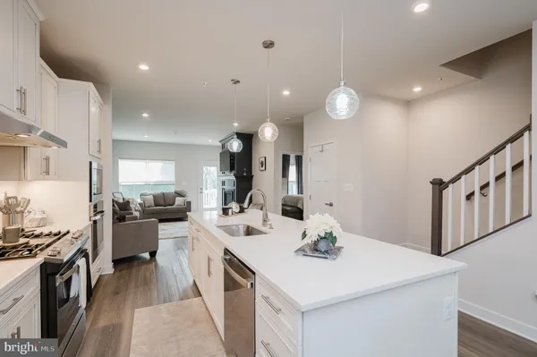 a kitchen with a sink a stove and chairs