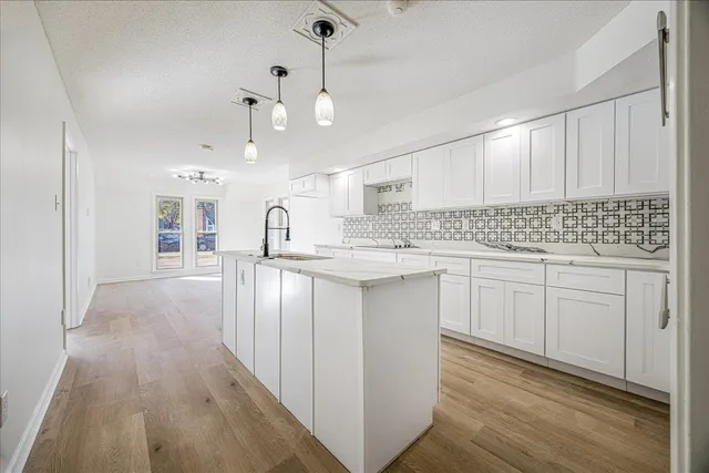 a kitchen with kitchen island granite countertop a sink cabinets and stainless steel appliances