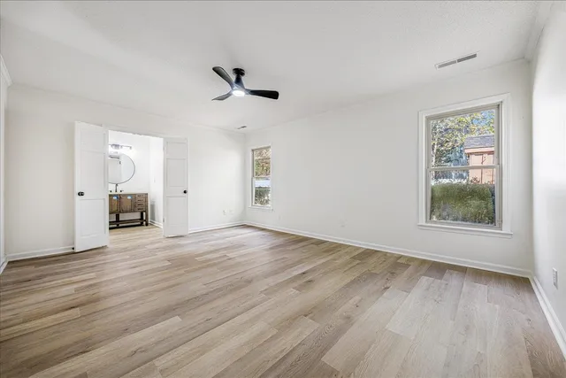 an empty room with wooden floor and windows