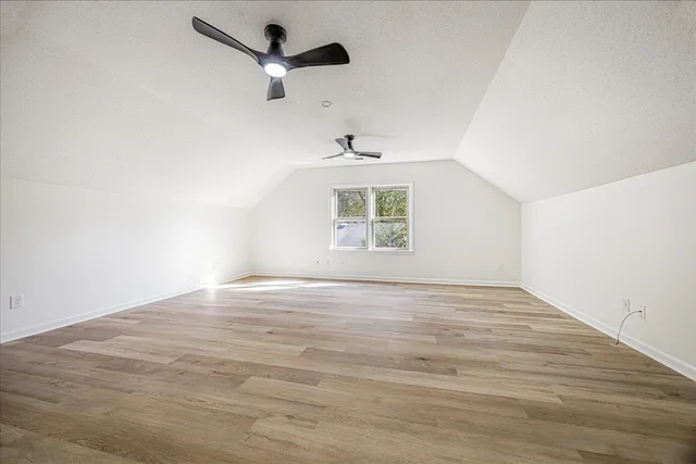 an empty room with a window and a ceiling fan