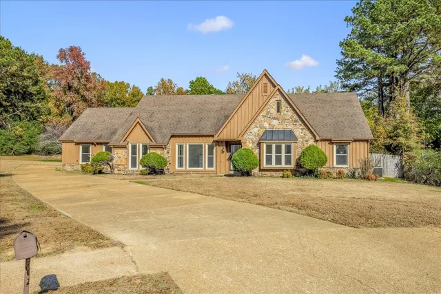 a view of a house with a yard and large tree