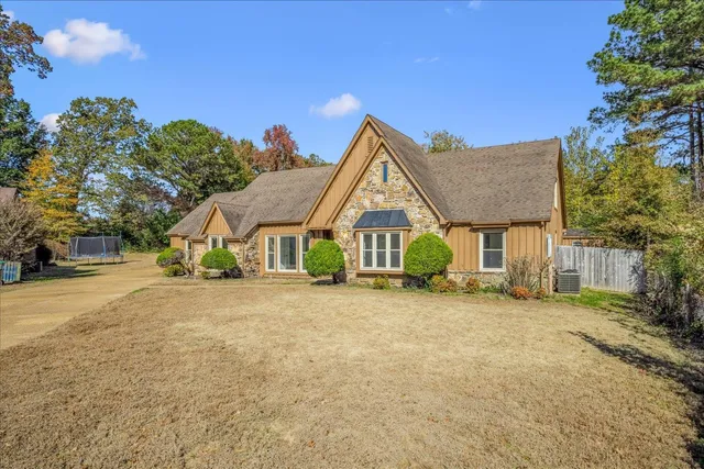 a front view of house with yard and trees in the background