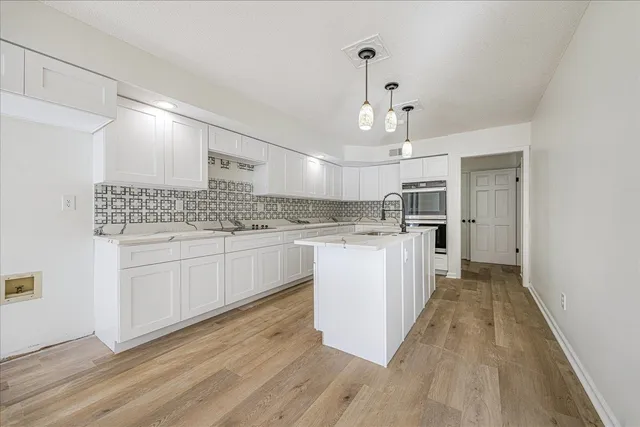 a kitchen with kitchen island white cabinets and white appliances