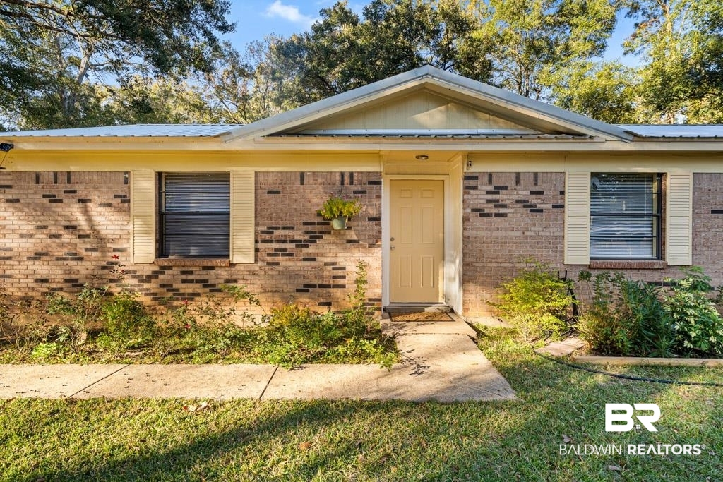 5551 Springer Court Theodore, AL 36582 - Photo 1 of 37 Doorway to property with brick siding and a lawn
