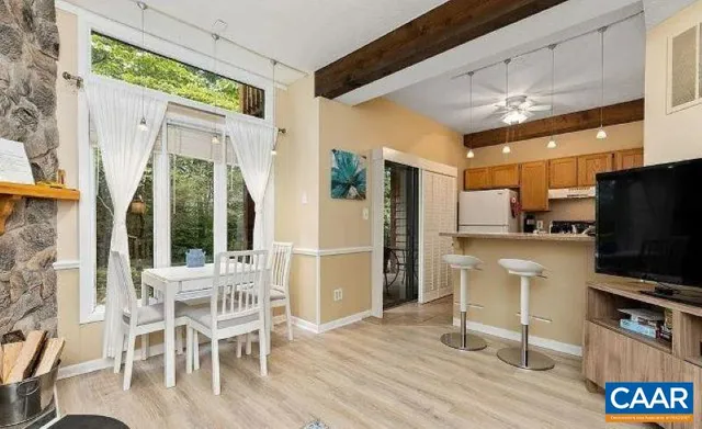 a kitchen with stainless steel appliances a dining table chairs refrigerator and sink