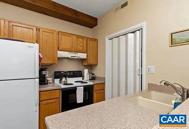 a kitchen with stainless steel appliances granite countertop a refrigerator stove sink and a refrigerator