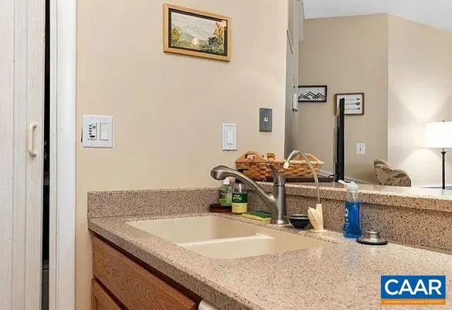a bathroom with a granite countertop sink and a mirror