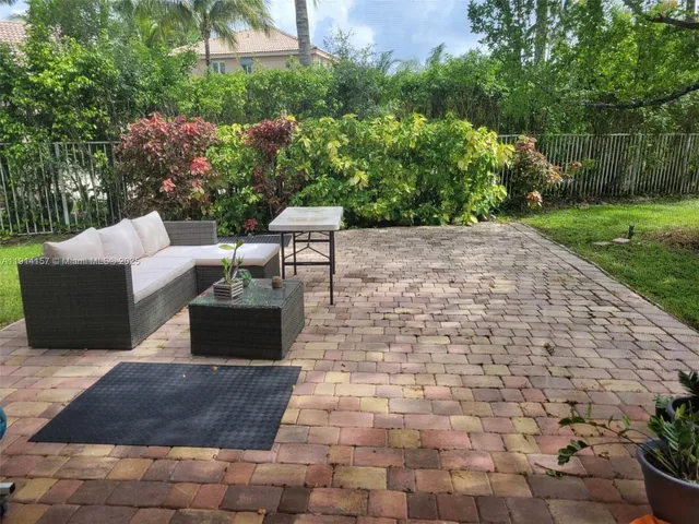 a view of a patio with table and chairs potted plants