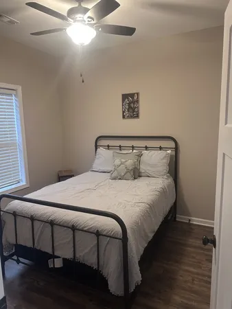 a bedroom with a bed and wooden floor