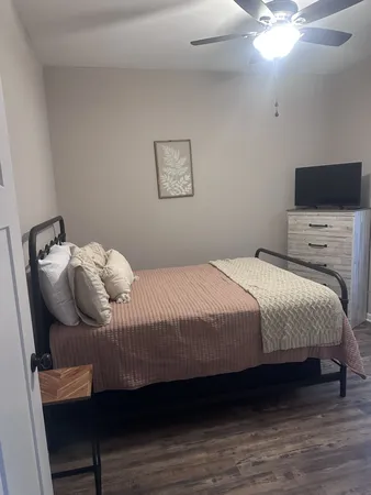 a bedroom with a bed and wooden floor