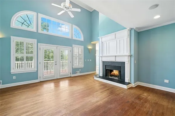 a view of an empty room with chandelier fan