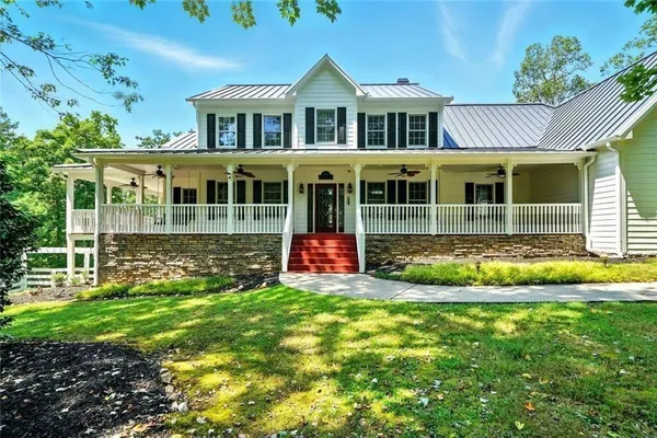 an empty room with wooden floor chandelier fan and windows