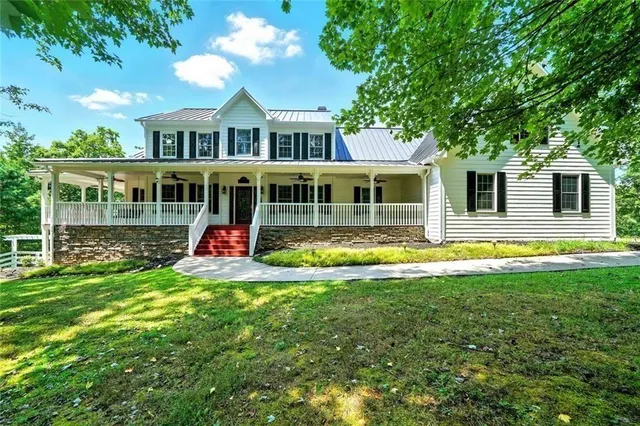 a view of an empty room with wooden floor and windows