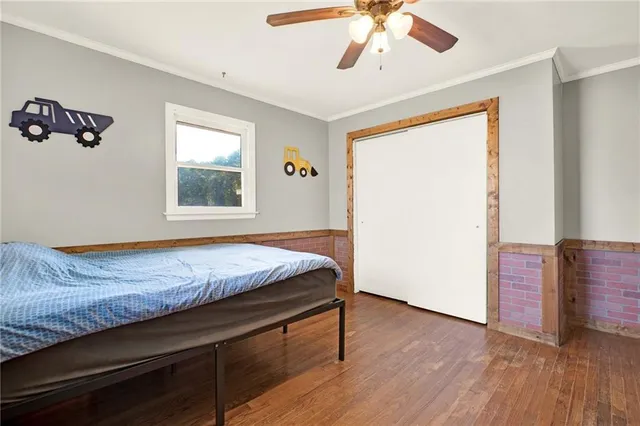 a bedroom with a bed and painting on the wall