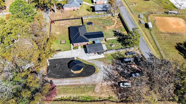 an aerial view of a house with garden space and a car parked
