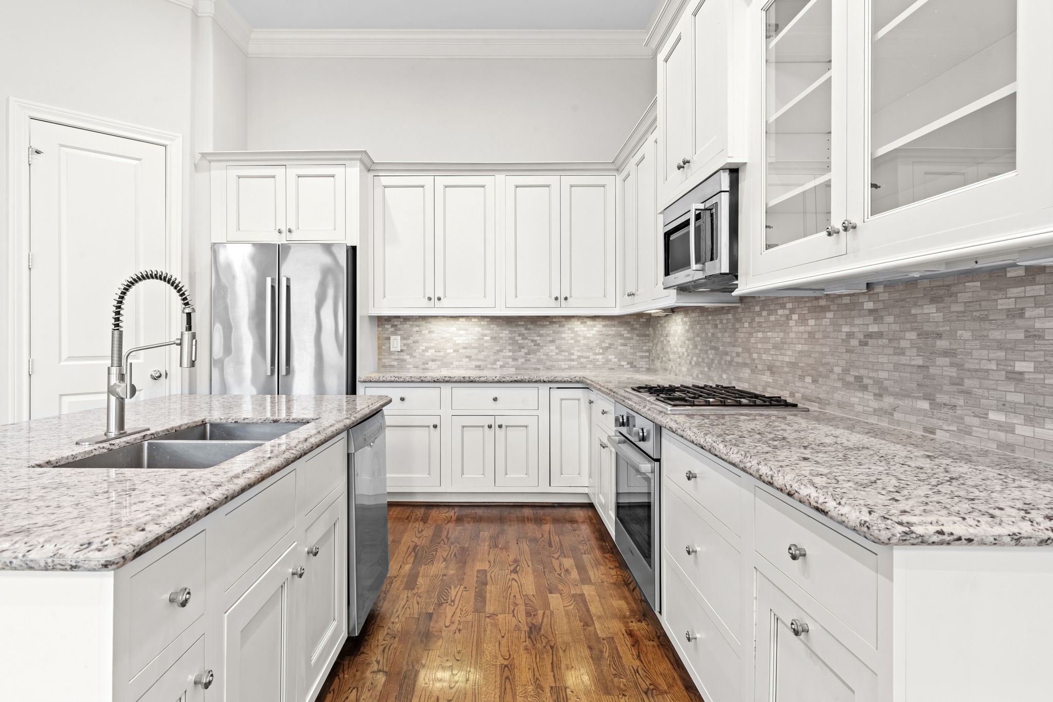 5621 Cohn Meadow Lane Houston, TX 77007 - Photo 8 of 35 Beautifully appointed kitchen with granite countertops, stainless steel appliances, and under-cabinet lighting, offering both style and functionality in an open-concept layout.