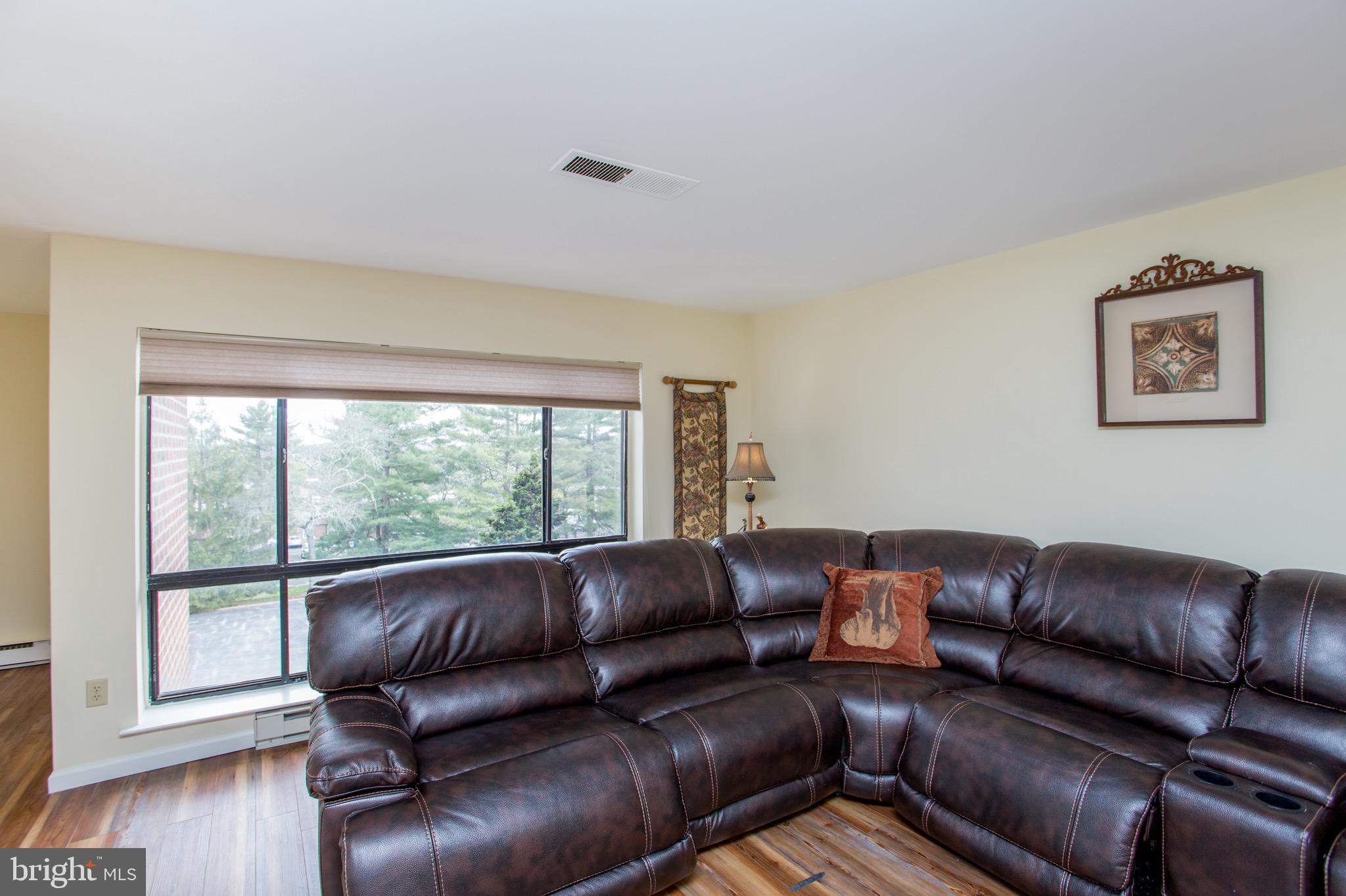 1680 Huntingdon Pike, Unit CONDO 224 Huntingdon Valley, PA 19006 - Photo 15 of 50 a living room with a couch wooden floor and a large window