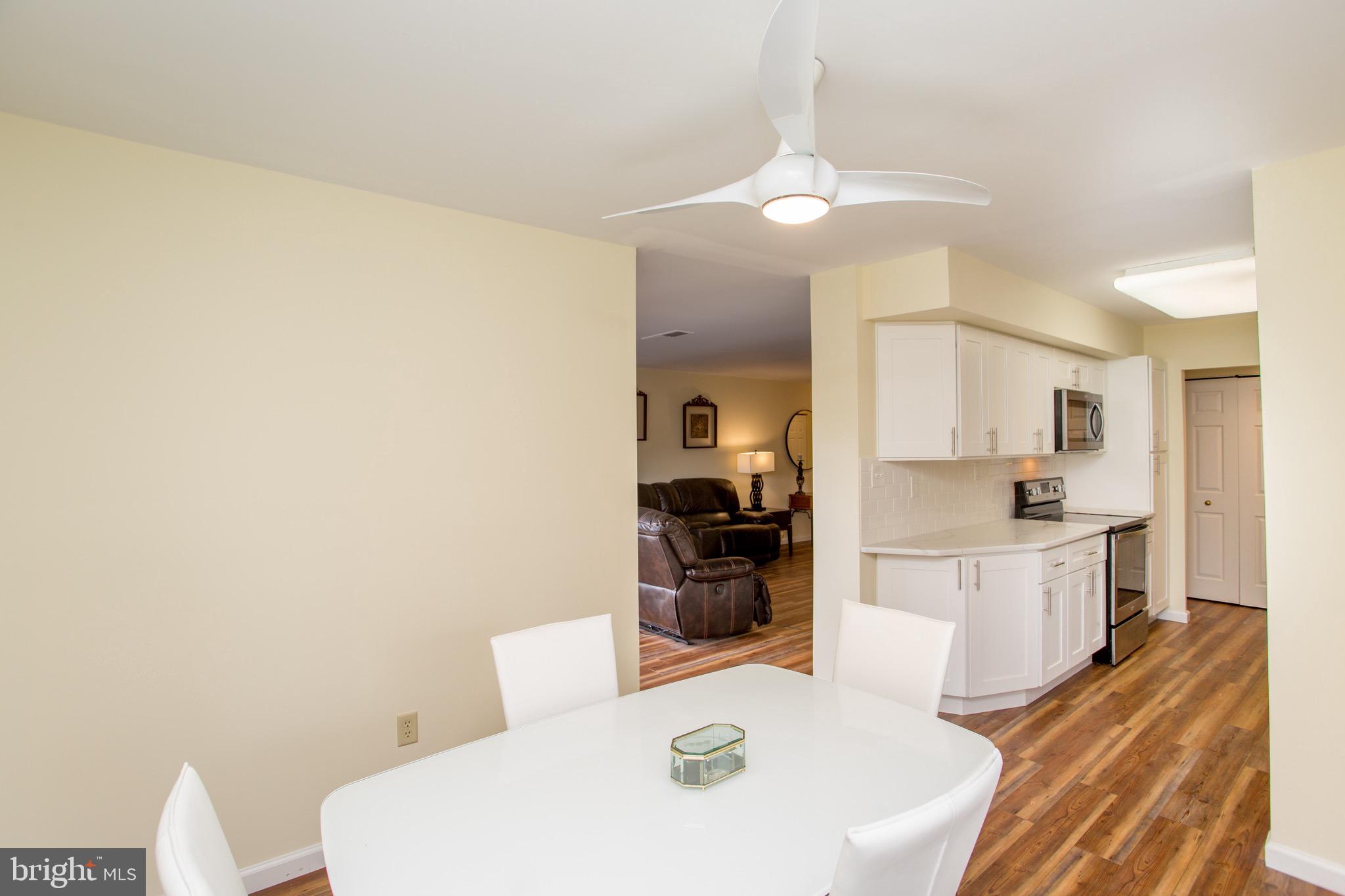 1680 Huntingdon Pike, Unit CONDO 224 Huntingdon Valley, PA 19006 - Photo 19 of 50 a large white kitchen with a sink and dishwasher a stove top oven with wooden floor