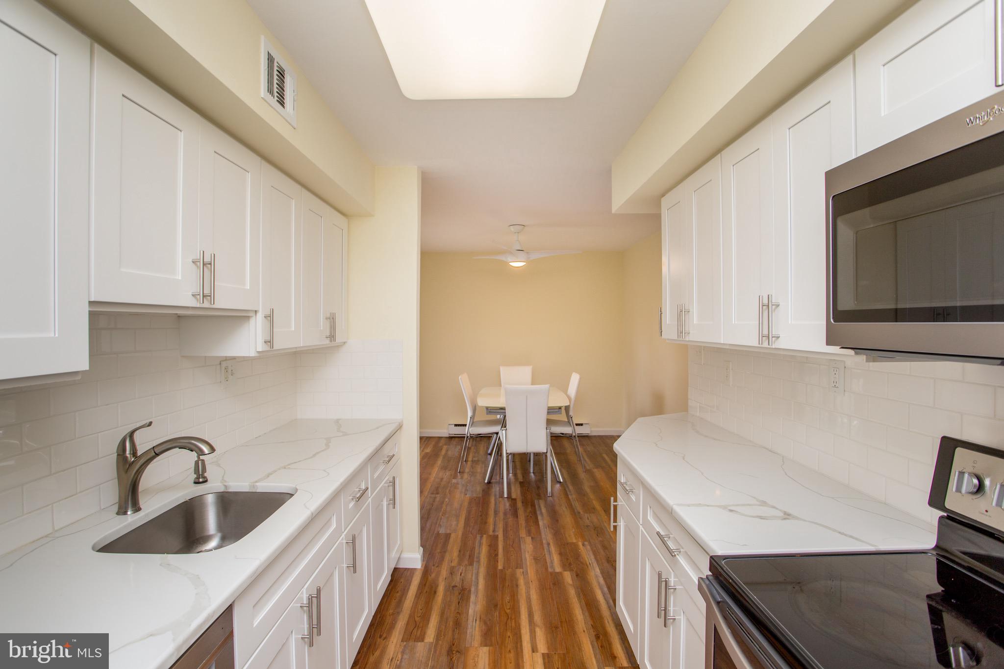 1680 Huntingdon Pike, Unit CONDO 224 Huntingdon Valley, PA 19006 - Photo 28 of 50 a kitchen with a sink a microwave a stove and cabinets