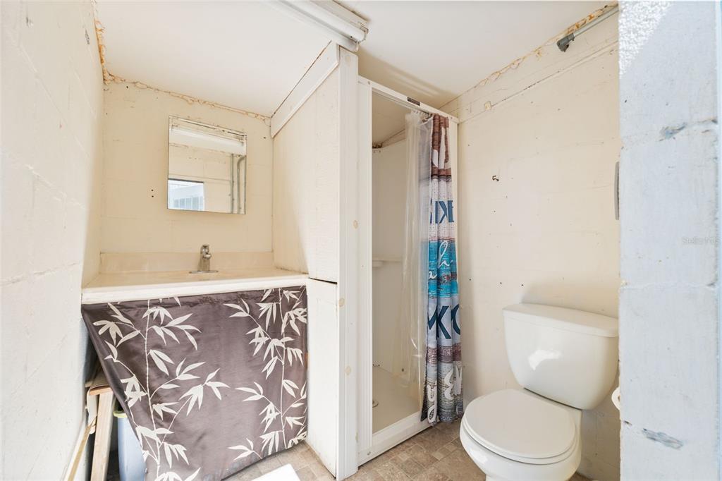 7965 West Riverbend Road Crystal River, FL 34428 - Photo 12 of 60 a white toilet sitting next to a bathroom sink and a shower