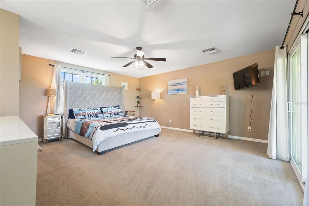 7965 West Riverbend Road Crystal River, FL 34428 - Photo 7 of 60 a spacious bedroom with a bed and a flat screen tv