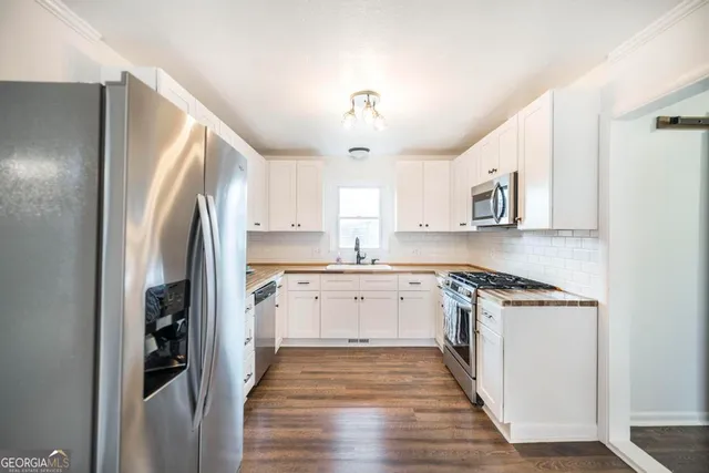 a kitchen with stainless steel appliances granite countertop a refrigerator and a stove top oven