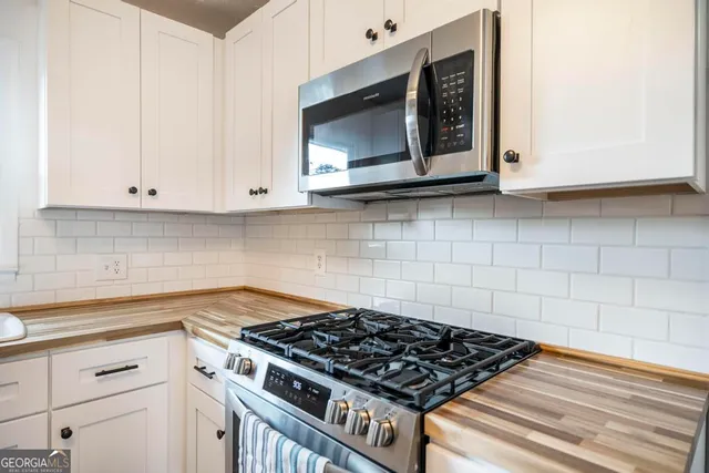 a kitchen with white cabinets and appliances