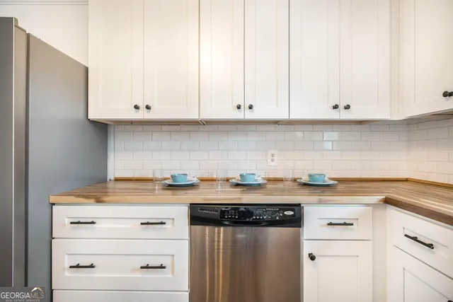 a kitchen with granite countertop white cabinets and white appliances
