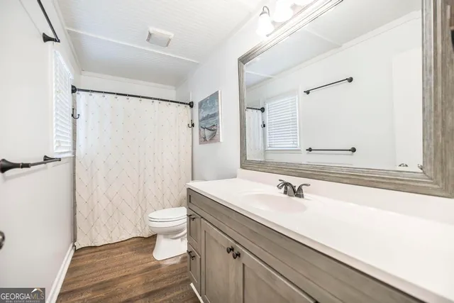 a bathroom with a sink a toilet a shower and a mirror