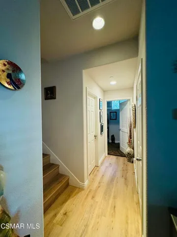 a view of a hallway with wooden shelves