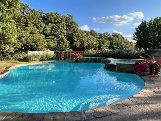 a view of a swimming pool with a yard and sitting area