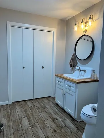 a bathroom with a toilet a sink and a mirror