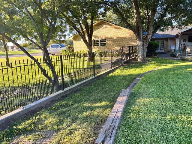a view of a house with a big yard and large trees