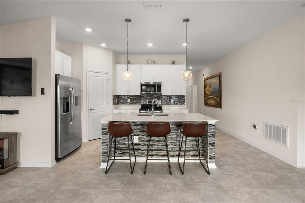 287 Inman Boulevard Winter Haven, FL 33881 - Photo 8 of 36 a kitchen with kitchen island a dining table chairs stainless steel appliances and cabinets