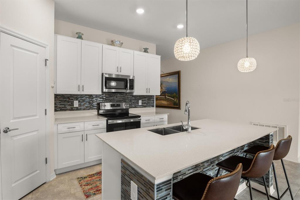 287 Inman Boulevard Winter Haven, FL 33881 - Photo 10 of 36 a kitchen with a table chairs and white cabinets